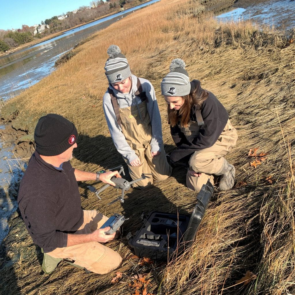 students doing research in marsh